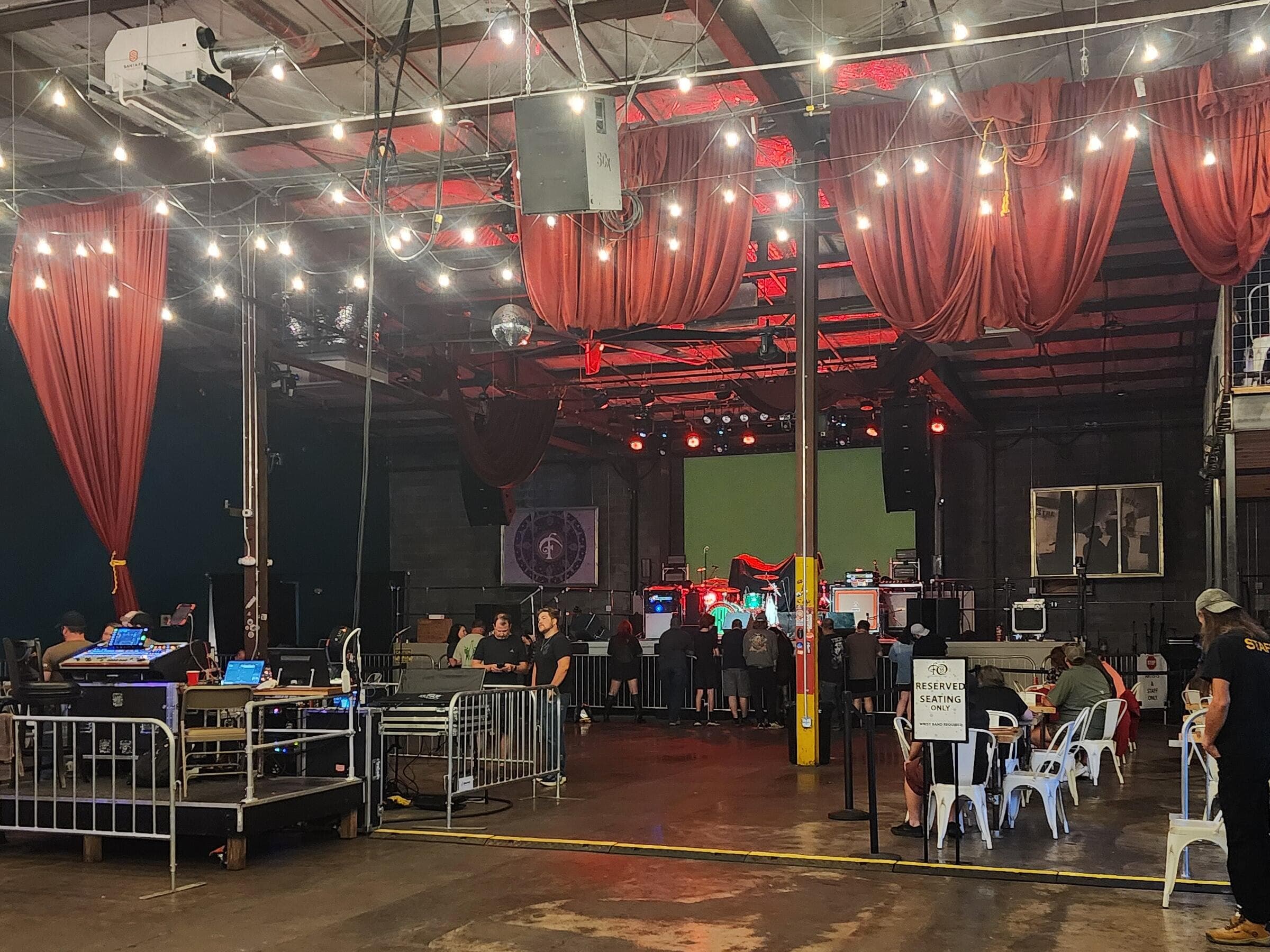 The Foundry at Basic City during set-up, with the crew at the sound desk and seating being put out on the floor.